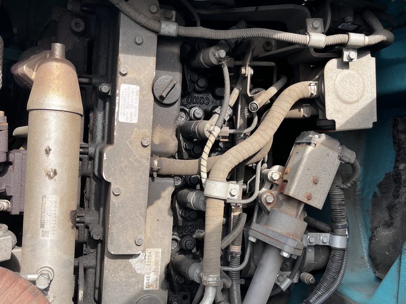 エンジンルームを開けて整備中の油圧ショベル